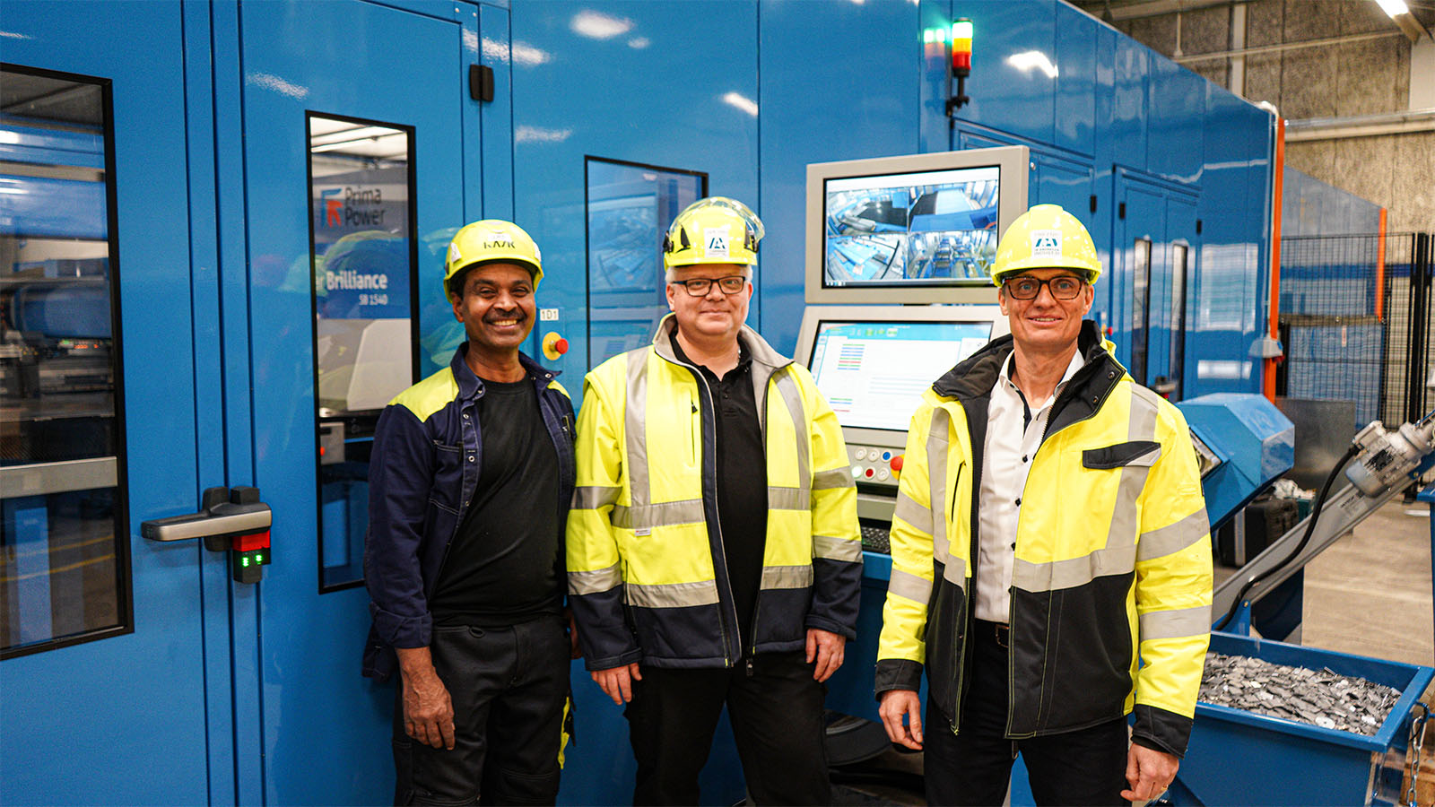 Tre medarbetare står framför Ib Andresen Industris nya stansningscenter.
